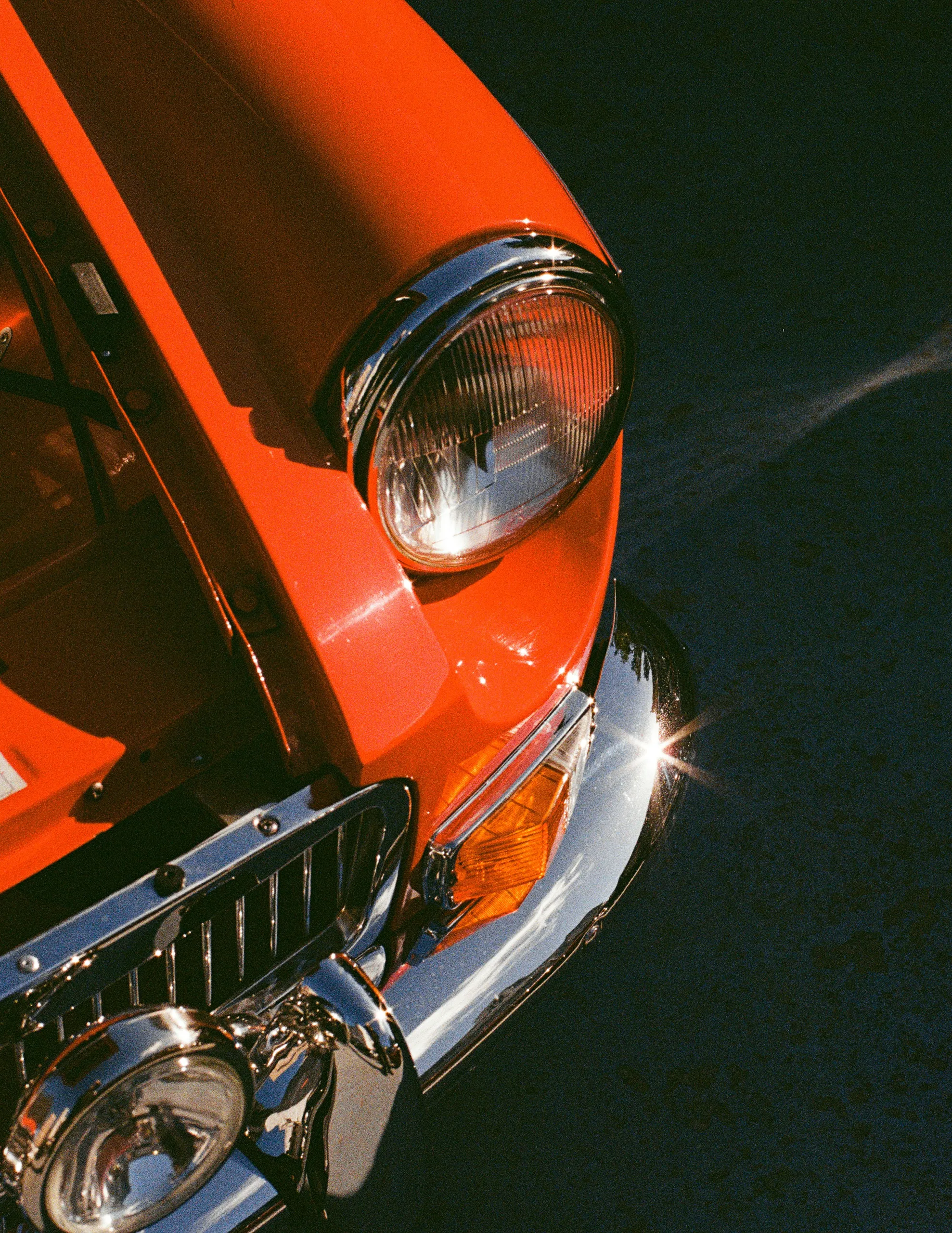 Coche clásico naranja, detalle del frontal y del faro tras el detailing
