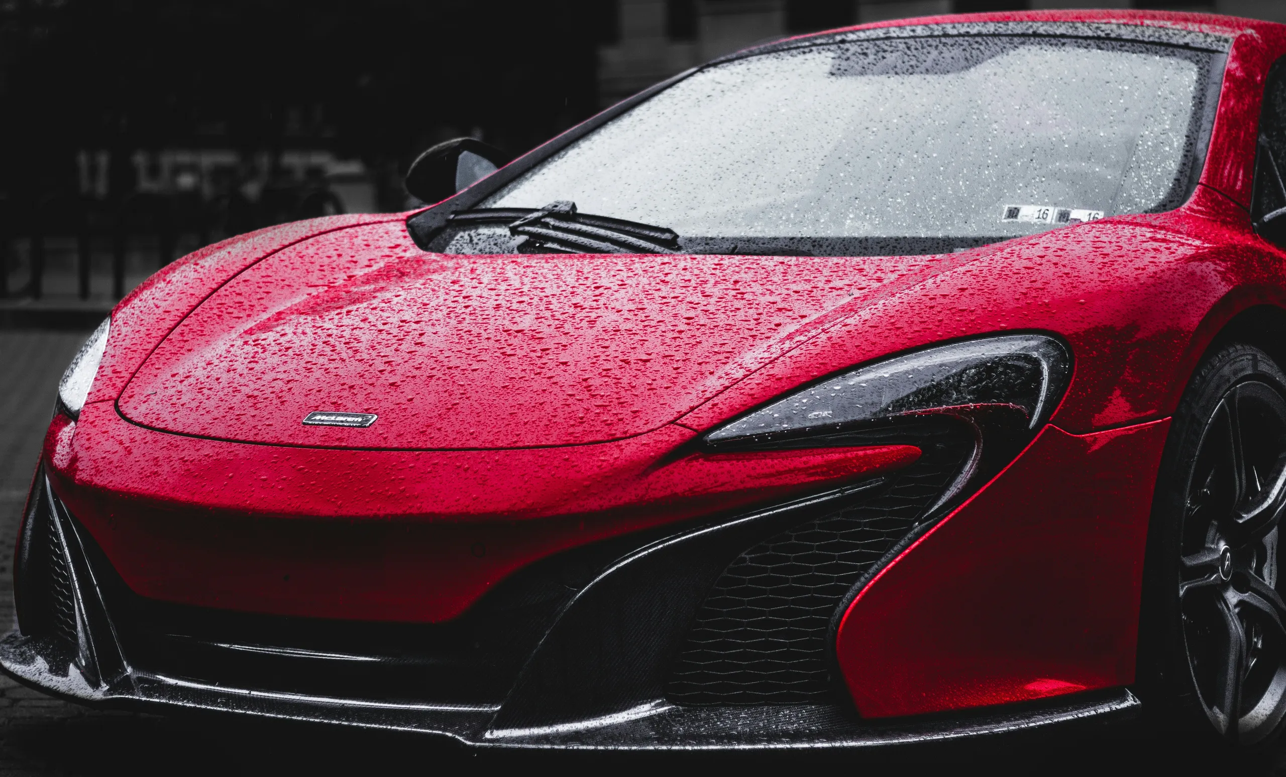 Coche rojo con gotas de agua deslizándose sobre el revestimiento cerámico